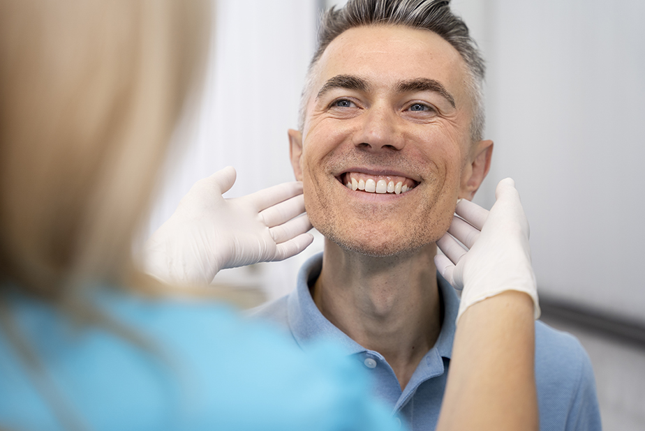 uomo che mostra i denti al medico