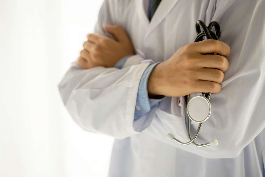Primo piano di braccia conserte di medico con camice