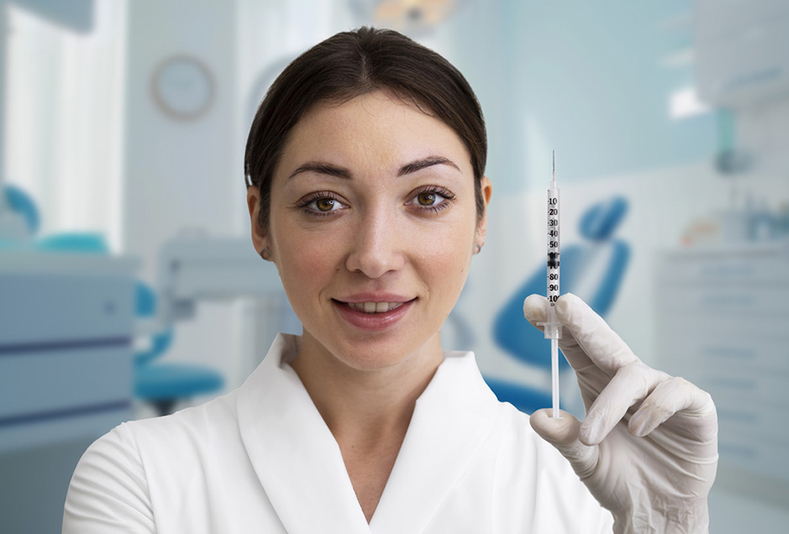Medico mostra siringa in uno studio odontoiatrico