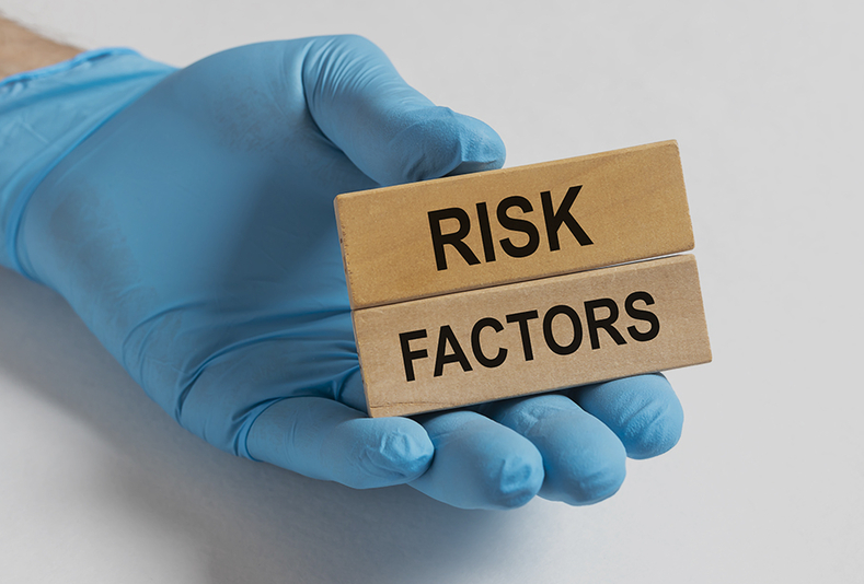 mano con un cartello con scritto Risk Factors