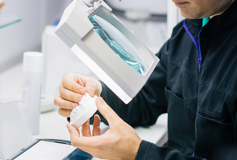 primo piano di mani di odontotecnico al lavoro