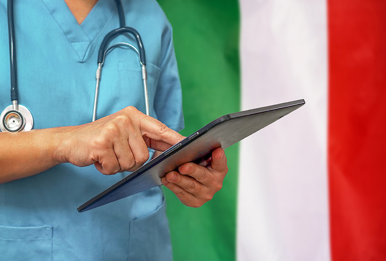 medico con bandiera italiana alle spalle