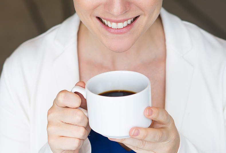 donna che sorride bevendo caffè