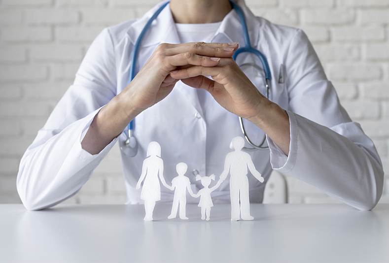 Medico con modellino di famiglia sulla scrivania