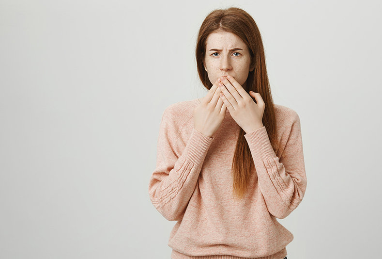 donna con mani sulla bocca