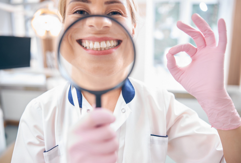 medico con lente di ingrandimento su sorriso