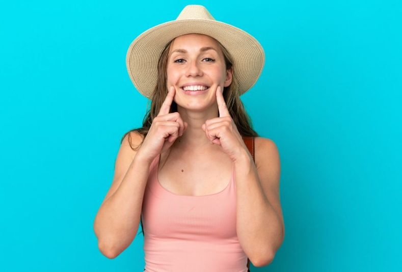 ragazza con cappello di paglia che indica sorriso