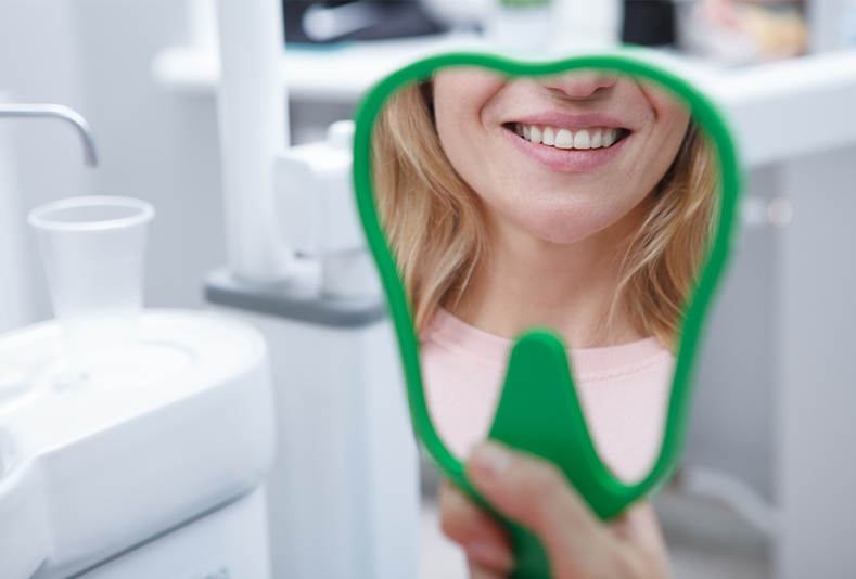Sorriso di donna su riflesso in specchio a forma di dente