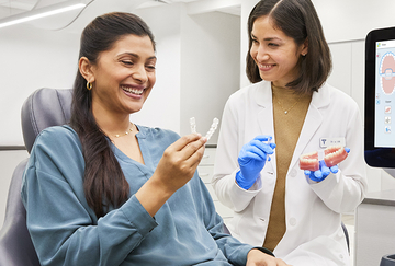 odontoiatra mostra allineatori trasparenti a paziente