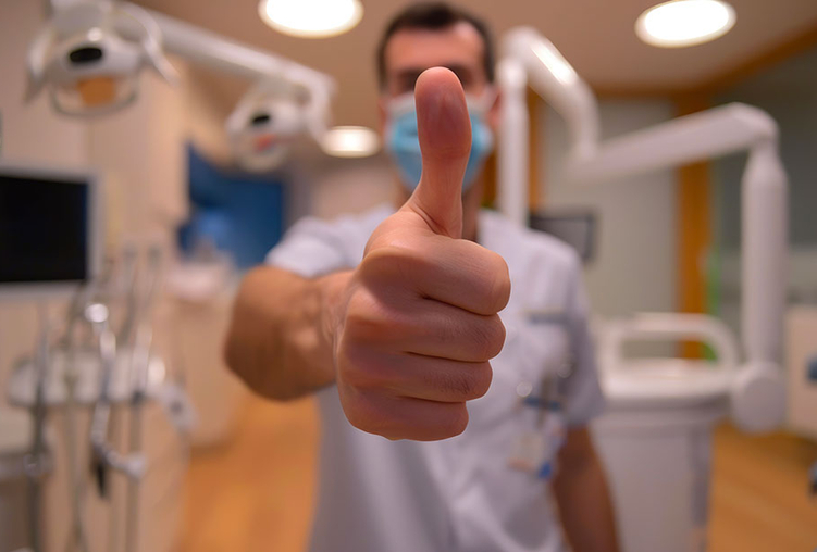 Professionista in studio con il pollice alzato in segno di ok