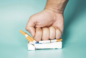 pugno schiaccia pacchetto di sigarette