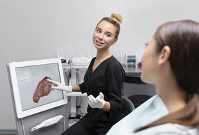 dentista illustra scansione intraorale a paziente 