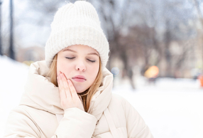 Donna sulla neve con mal di denti