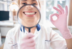 medico con lente di ingrandimento su sorriso