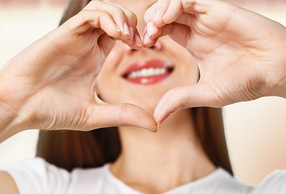 ragazza che fa il simbolo del cuore con le mani