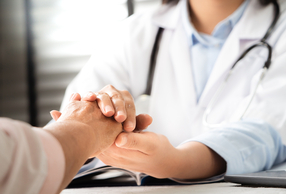Primo piano di medico che stringe le mani a paziente