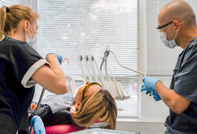 odontoiatra e assistente con paziente su riunito in visita