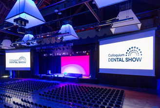 sala congressi con maxi-schermi con logo di Colloquium Dental Show