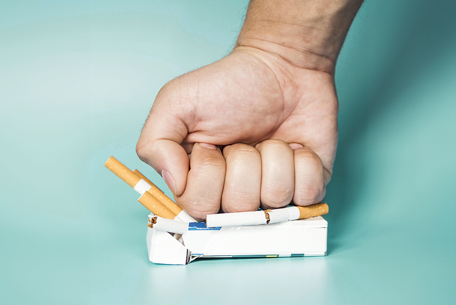 pugno schiaccia pacchetto di sigarette