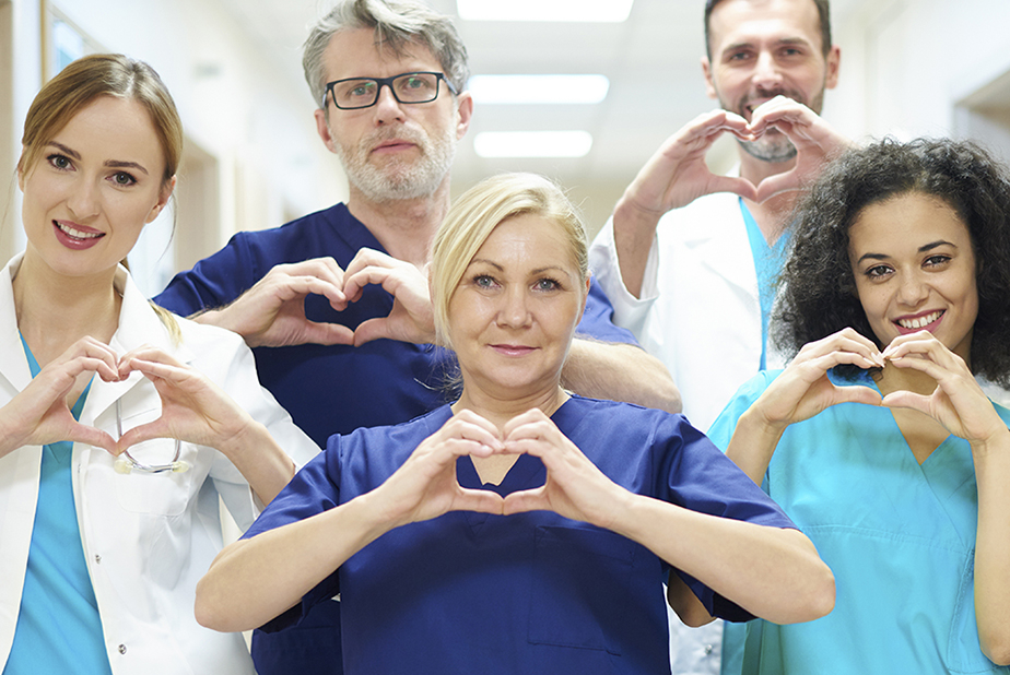 personale sanitario forma un cuore con le mani