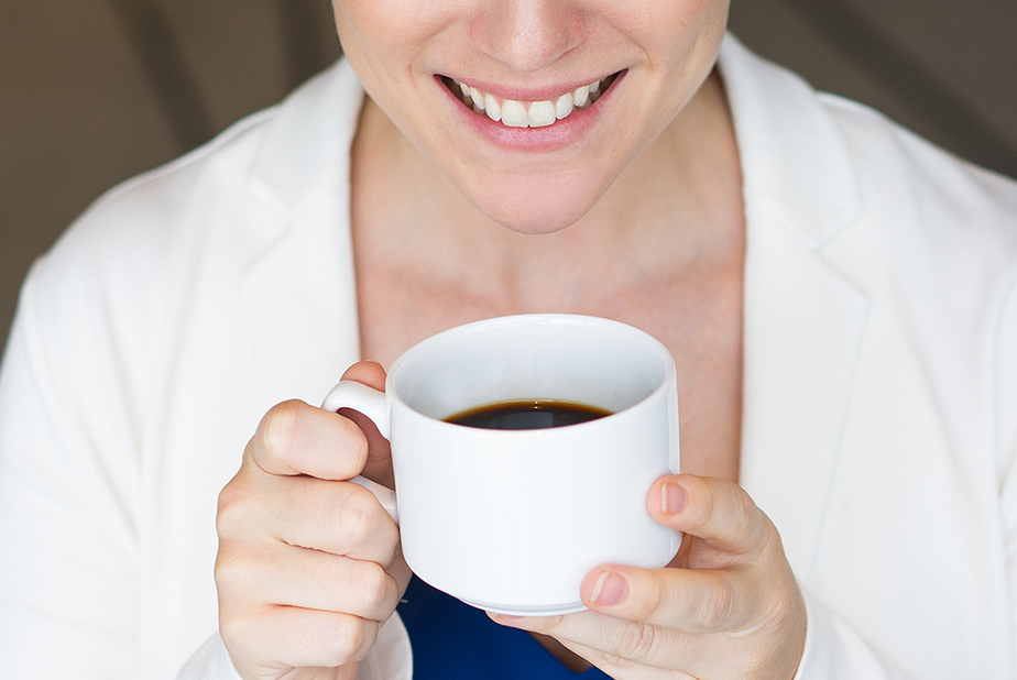 Caffeina come protezione contro la perdita ossea da parodontite apicale donna che sorride bevendo caffè