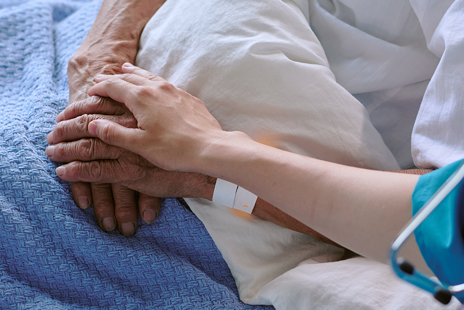 paziente a letto e mano di professionista sanitario