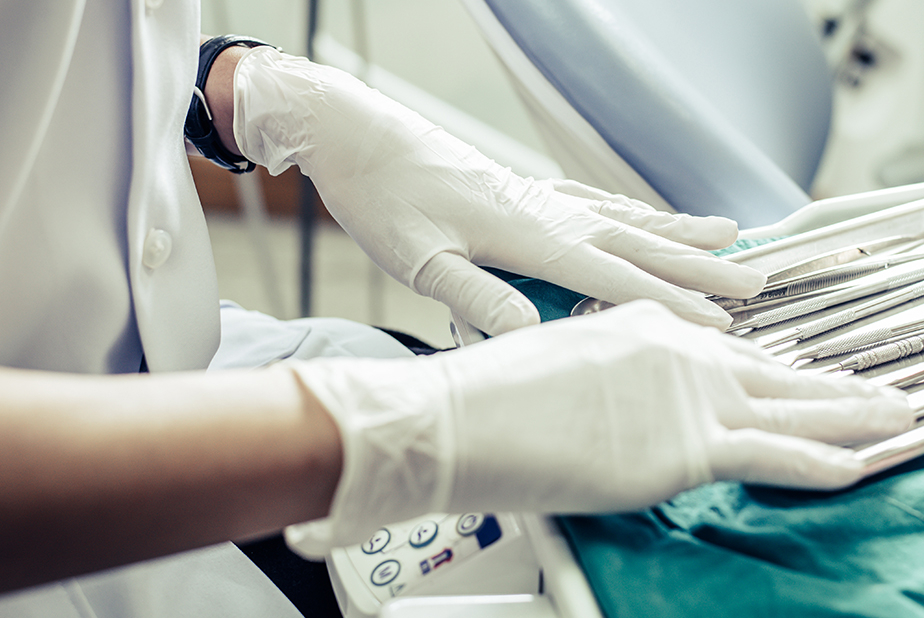 Primo piano di mani di un dentista con i guanti 