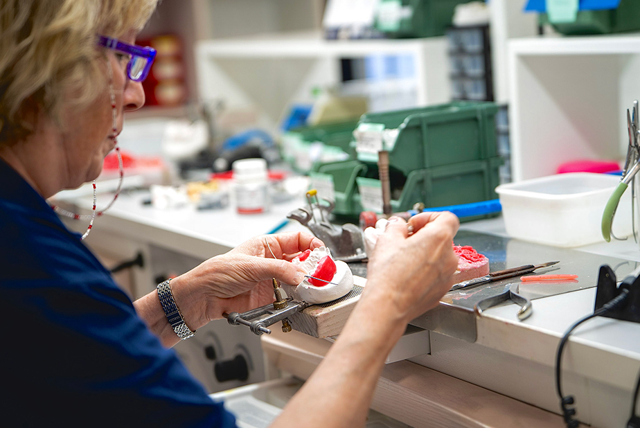 signora che lavora ad una protesi in laboratorio