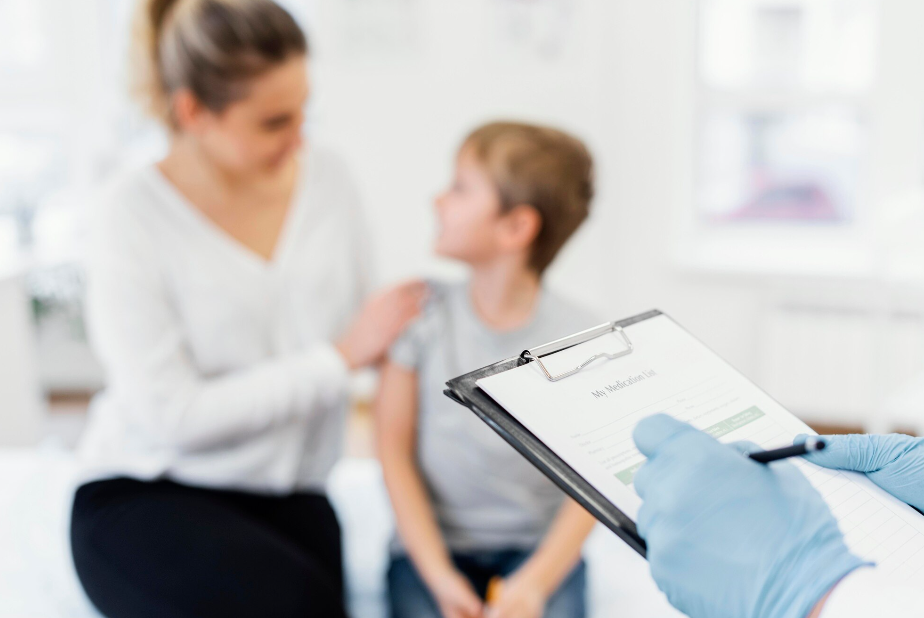 mani di medico in primo piano con mamma e bambino sullo sfondo