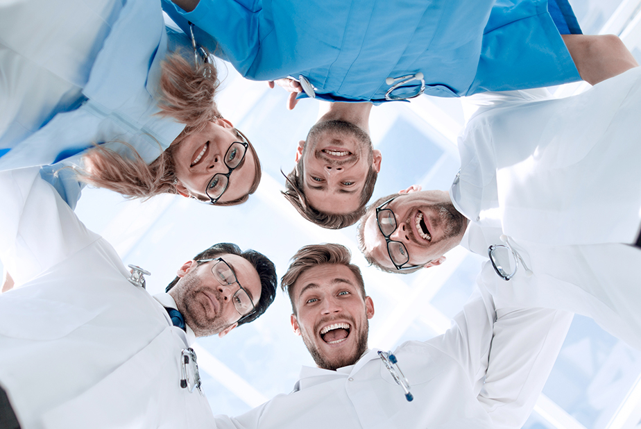 Medici disposti a cerchio che sorridono