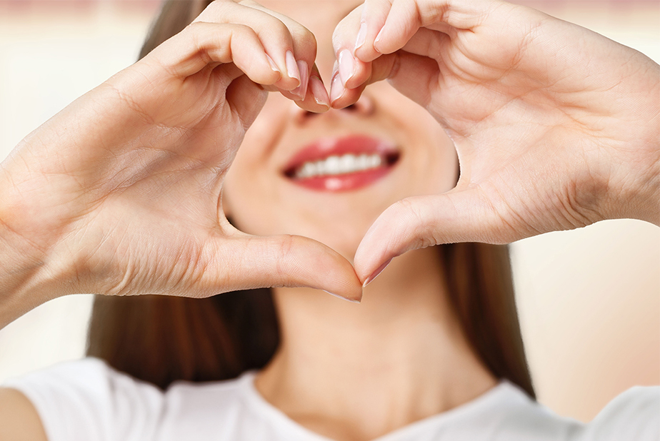 Giornata Mondiale del Cuore: la salute cardiovascolare passa anche dalla bocca ragazza che fa il simbolo del cuore con le mani