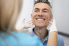 uomo che mostra i denti al medico
